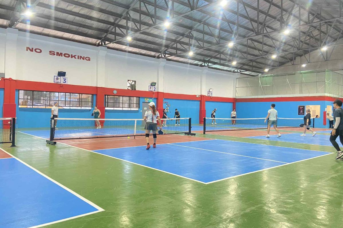 Several numbered indoor pickleball courts in use side by side.