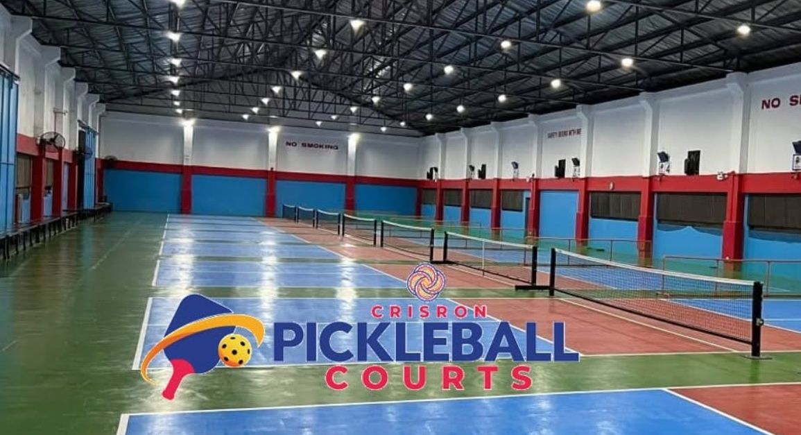 The Crisron hall between sessions, showing the full row of marked courts and nets.
